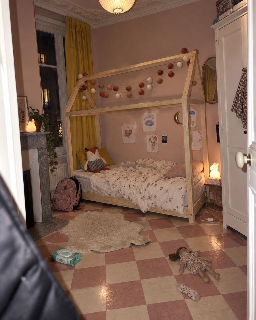 Lit cabane dans une petite chambre rose avec une cheminée